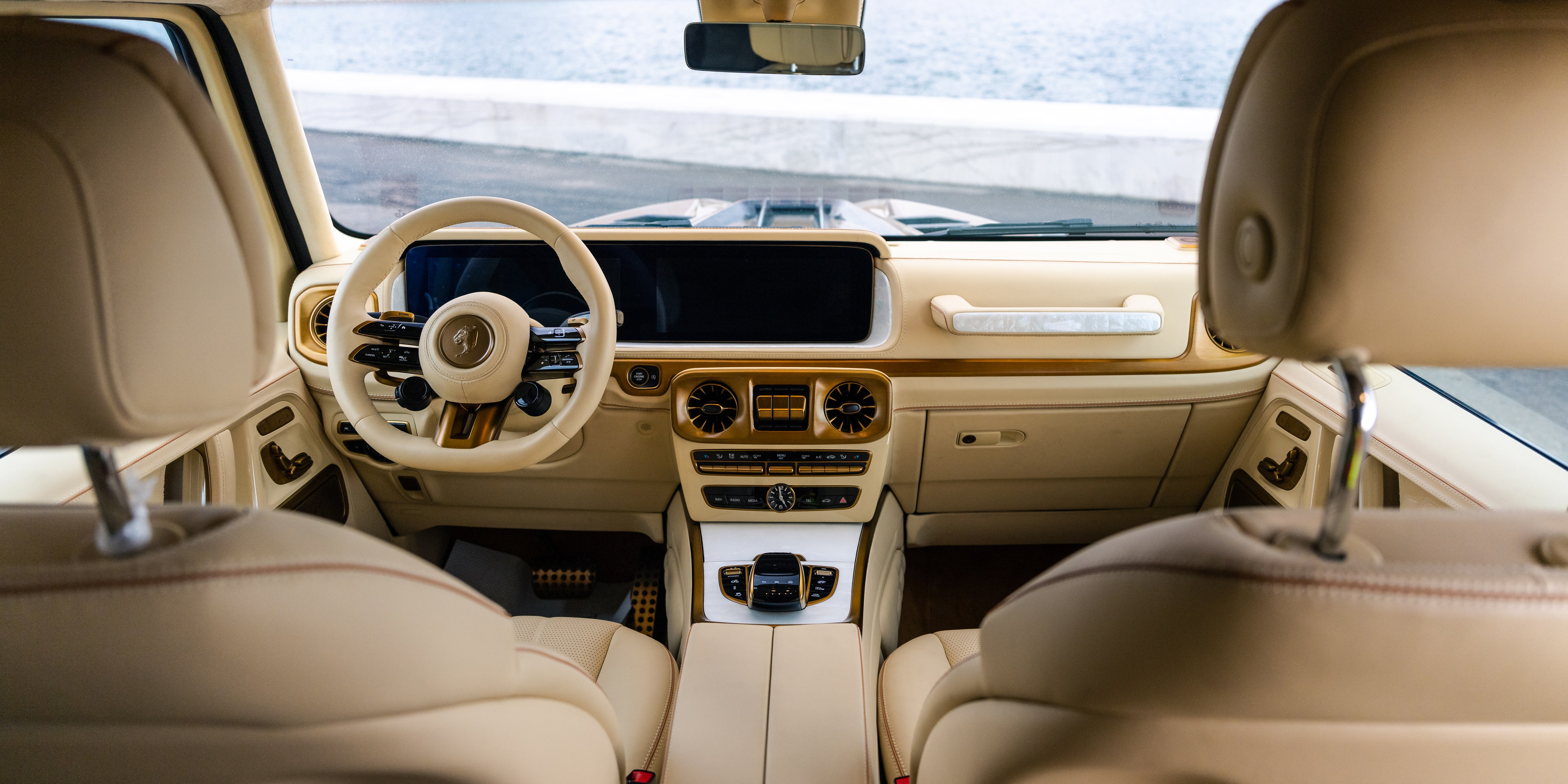 Full cabin overview — symmetrical view from rear, gold accents on dash and steering, Toronto waterfront through windshield