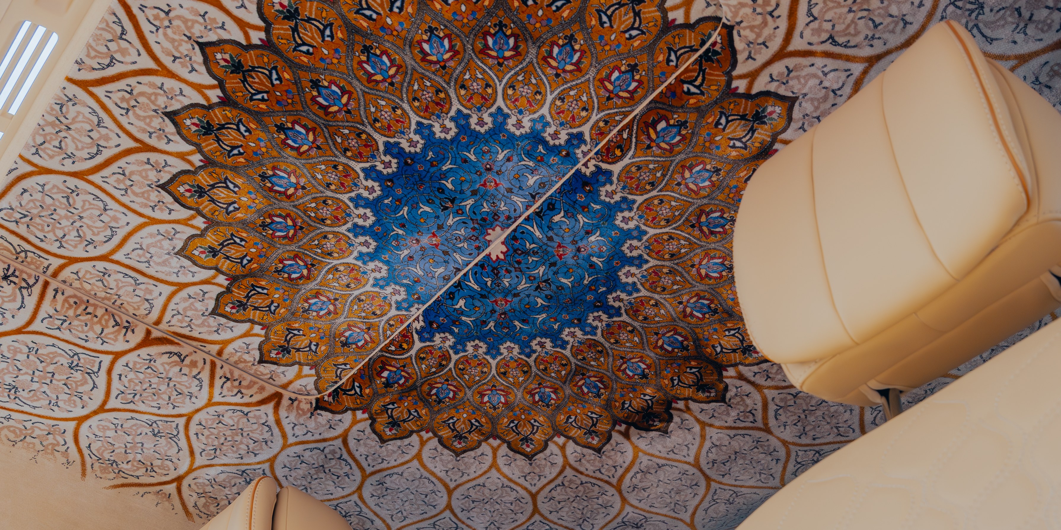 Hand-knotted Persian silk roofliner — central medallion and floral tracery field, viewed between the front and rear seating positions